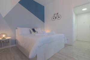 a white bedroom with a bed with towels on it at Sesto Sky Design - Sesto Rondò in Sesto San Giovanni