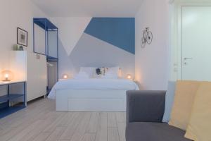 a bedroom with a white bed and a couch at Sesto Sky Design - Sesto Rondò in Sesto San Giovanni