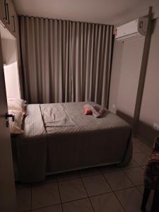 a small bed in a room with a window at Flat charmoso vista mar in Recife +3 photos