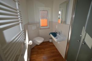 a small bathroom with a toilet and a sink at Gartenhaus 2, inkl 1 Parkplatz in Fehmarn