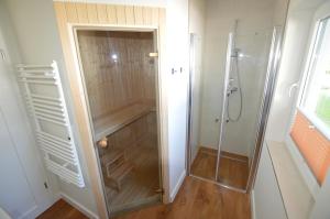 a shower with a glass door in a bathroom at Gartenhaus 2, inkl 1 Parkplatz in Fehmarn