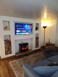 a living room with a fireplace and a flat screen tv at South view farm cottage 2 Bed in Thornton +16 photos