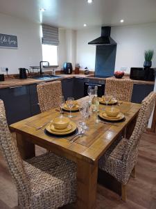 a wooden table with plates and glasses on it in a kitchen at South view farm cottage 2 Bed in Thornton