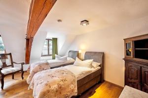 a bedroom with a bed and two chairs at Quellenhof - Wohnen im Denkmal - Wohnung BURG in Blankenheim