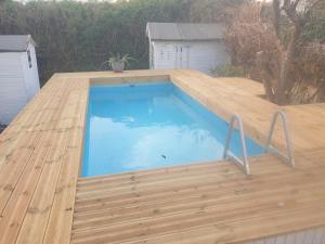 a swimming pool on top of a wooden deck at B&B La Dolce Vita in Flumini di Quartu