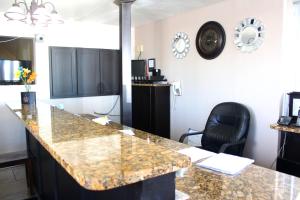 a kitchen with a granite counter top and a black chair at Budget Inn - St. Petersburg in St Petersburg