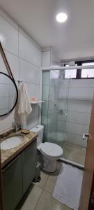 a bathroom with a toilet and a sink and a mirror at Apartamento aconchego Atalaia in Luis Correia +4 photos