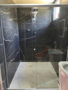 a bathroom with a shower with a glass door at Hostel Big Ben in Paranapiacaba +49 photos