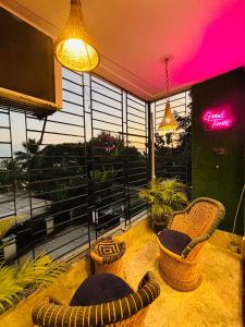 une chambre avec deux chaises et un balcon avec vue dans l'établissement Lily Homes, à Guwahati