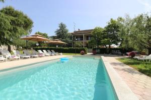 a swimming pool with chairs and an umbrella at Ferienhaus - Bungalow Lavanda 4 in Poreč