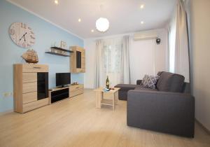 a living room with a couch and a clock on the wall at Ferienhaus - Bungalow Lavanda 4 in Poreč +17 photos