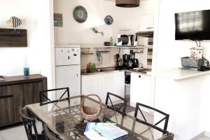 Una cocina con una mesa de cristal y sillas. en Modern apartment in Val André 50m from the sea, en Pléneuf-Val-André