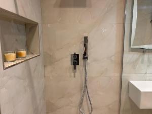 une douche avec pommeau de douche dans une salle de bain dans l'établissement Elisabeth Apartments 3, à Saranda 10 autres photos
