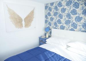 a bedroom with a bed and a blue and white wall at Esmeralda Holiday Home in Bracciano