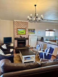 een woonkamer met een bank en een open haard bij Sea Cottage on Julia in Franskraalstrand