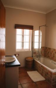 een badkamer met een bad en een wastafel bij Sea Cottage on Julia in Franskraalstrand