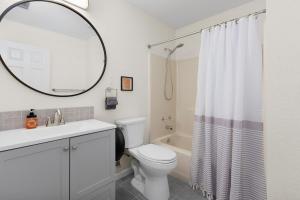 a bathroom with a toilet and a sink and a mirror at Air Haus in Fourth Crossing +19 photos