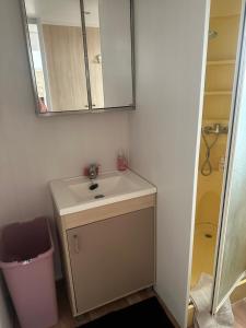 a bathroom with a sink and a mirror at Mobil-home tout équipé à louer in Villeneuve-lès-Maguelonne +7 photos