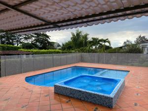 une grande piscine dans un patio avec une clôture dans l'établissement Finca LA BONITA Eje Cafetero, à La Tebaida