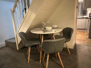 a table with four chairs and wine glasses on it at Abbey Cottage in Llangollen