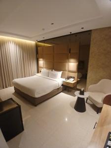 une chambre avec un lit, un canapé et une chaise dans l'établissement XYZ Hotel Qurtoba, à Riyad