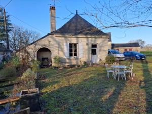 an old house with a table and chairs in the yard at Moulin Rondard in Grézillé