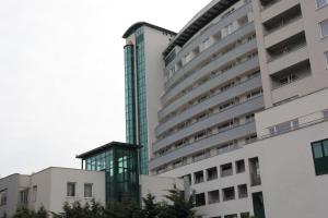 wysoki biały budynek ze szklanymi oknami w obiekcie Apartamenty Kolorowe Etna w Kołobrzegu