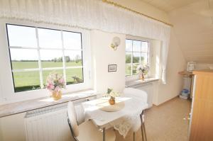 ein Esszimmer mit einem Tisch und zwei Fenstern in der Unterkunft Müller 4 - a10797 in Dahme