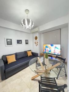 a living room with a blue couch and a glass table at UIM Mediterraneo Virgen del Carmen 2 Wifi in Puerto de Sagunto