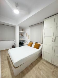 a white bedroom with a large bed and white cabinets at UIM Mediterraneo Virgen del Carmen 2 Wifi in Puerto de Sagunto
