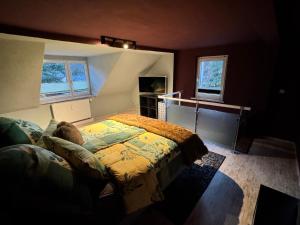 a bedroom with a bed and a desk and two windows at ErzgebirgsLoft in Annaberg-Buchholz