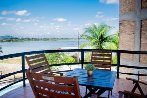 un tavolo e sedie su un balcone con vista sull'acqua di Hotel Pousada Do Lago a Campo Maior