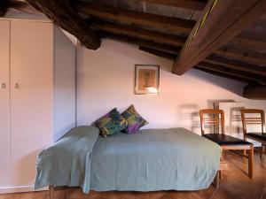 a bedroom with a bed in a room with chairs at Casa Del Borgo Valpolicella in San Pietro in Cariano