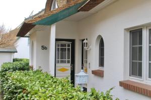 a white house with a front door and a mailbox at Godeke Michels Ferienwohnung 24 Seestr5b in Groß Kirr