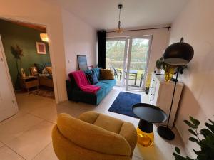 a living room with a couch and a chair at Bursztynowy Apartament in Jantar