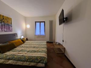 a bedroom with a bed and a flat screen tv at Casa Del Borgo Valpolicella in San Pietro in Cariano