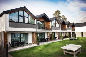 una vista exterior de una casa con un patio verde en Domki Gold-Time Niechorze, en Niechorze