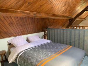a bedroom with a bed and a wooden ceiling at La MAISON d'AUBUSSON in Aubusson