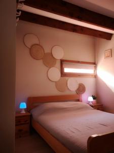 - une chambre avec un lit et une fenêtre avec des cercles sur le mur dans l'établissement Appartement 600M de la plage, à Port-la-Nouvelle