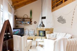 a living room with white furniture and a fireplace at Bungalow Seestern in Malchow +16 photos
