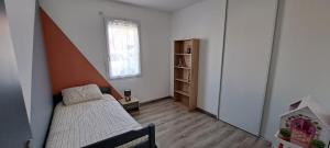 a small bedroom with a bed and a window at Maison 3 chambres in Parentis-en-Born