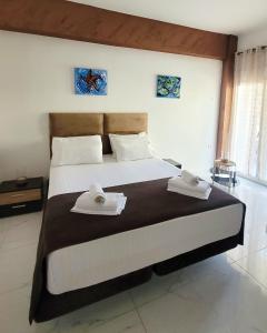 a bedroom with a large bed with two towels on it at Villa Sonja in Neoi Epivates
