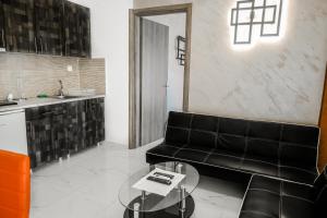 a living room with a black couch and a table at Villa Sonja in Neoi Epivates
