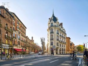 a city street with buildings and people riding bikes at Le Drapier - Centre - Luxe - Chalets in Toulouse