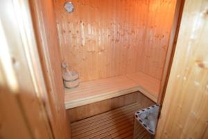 a small wooden sauna with a bucket in it at Reetdachhaus 5, inkl 2 Parkplätze in Fehmarn