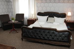 een slaapkamer met een groot bed en 2 stoelen bij Motel Łużycki & Restauracja in Lubań
