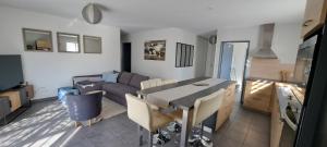 a kitchen and living room with a table and a couch at Maison 3 chambres in Parentis-en-Born +8 photos