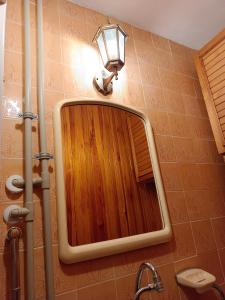 a bathroom with a mirror and a light on the wall at U Rafcia in Warsaw +53 photos