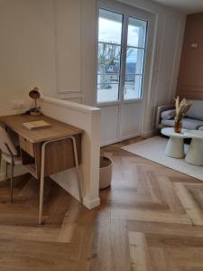 ein Wohnzimmer mit einem Schreibtisch und einem Fenster in der Unterkunft Le Boudoir d'Elba - Balneotherapie & terrasse in Meyssac + 25 Fotos