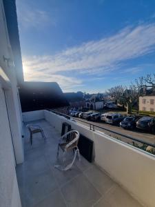 einen Stuhl auf einem Balkon mit Blick auf einen Parkplatz in der Unterkunft Le Boudoir d'Elba - Balneotherapie & terrasse in Meyssac